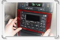 A person is adjusting the radio in a car, using an interior car kit.